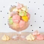 Meringue kisses piled high in glass dish.