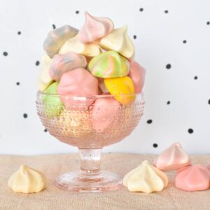 Meringue kisses piled high in glass dish.