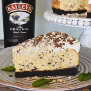 Bailey's Cheesecake Slice with Bailey's bottle in background.