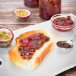 Passionfruit Jam on toast with jam jar in background.