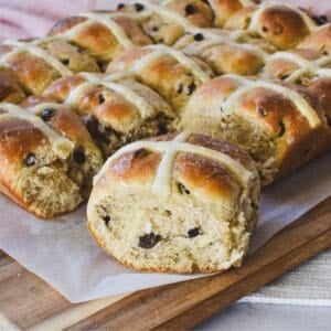 Hot Cross Buns freshly baked on wooden board.