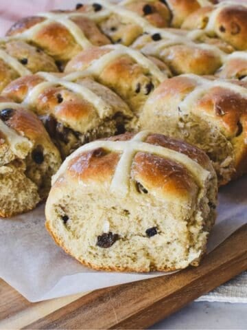 Hot Cross Buns freshly baked on wooden board.
