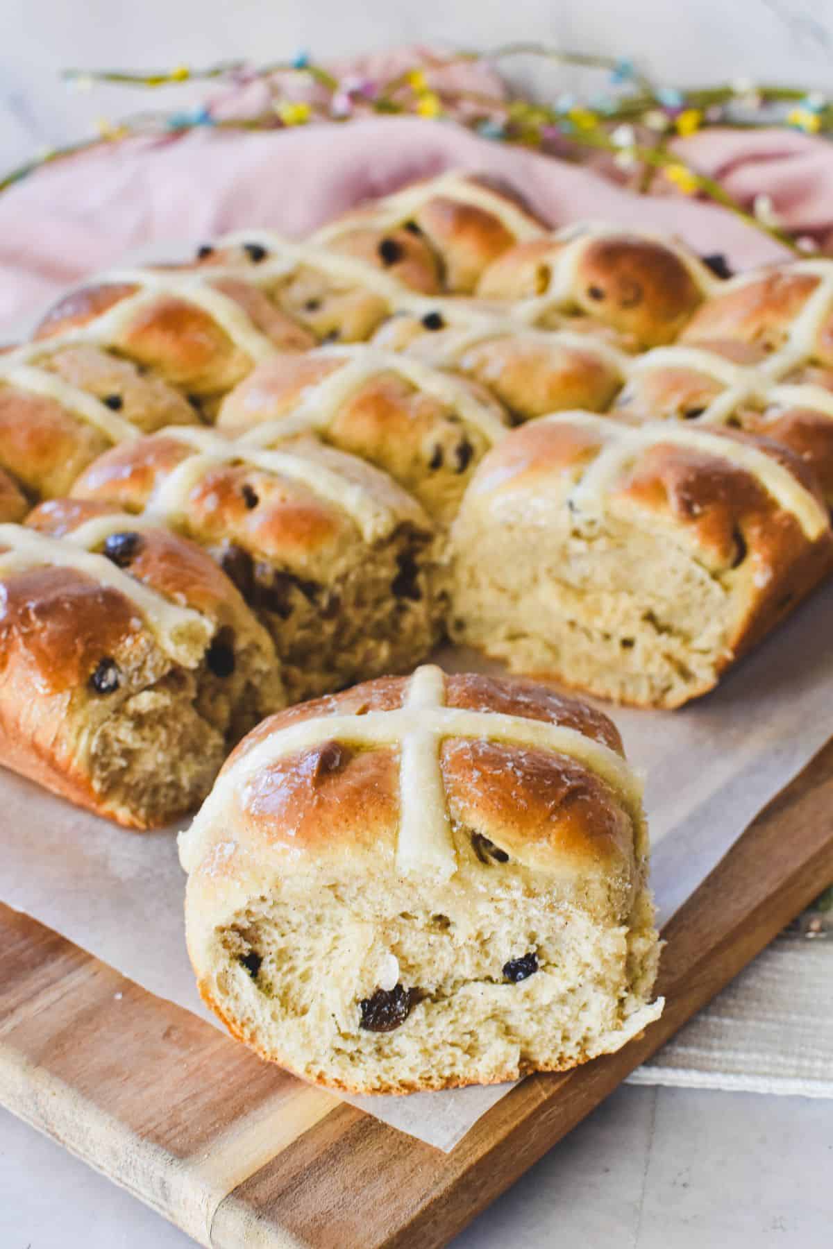 Hot Cross Buns served on wooden tray.
